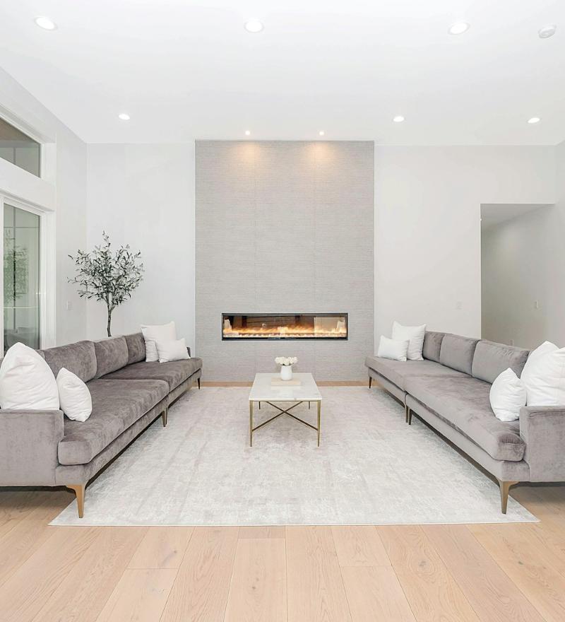 Bright modern living room with grey sofas and a fireplace